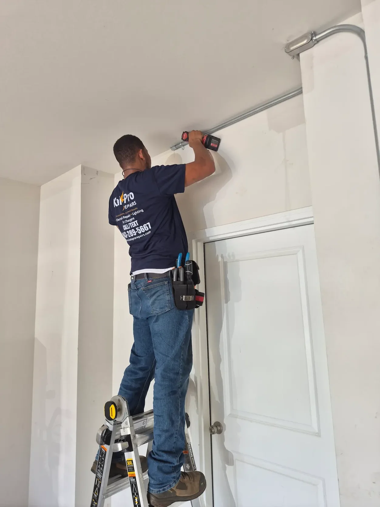 Kais Pro Repairs technician installing conduit along a garage wall for a ChargePoint Level 2 charger