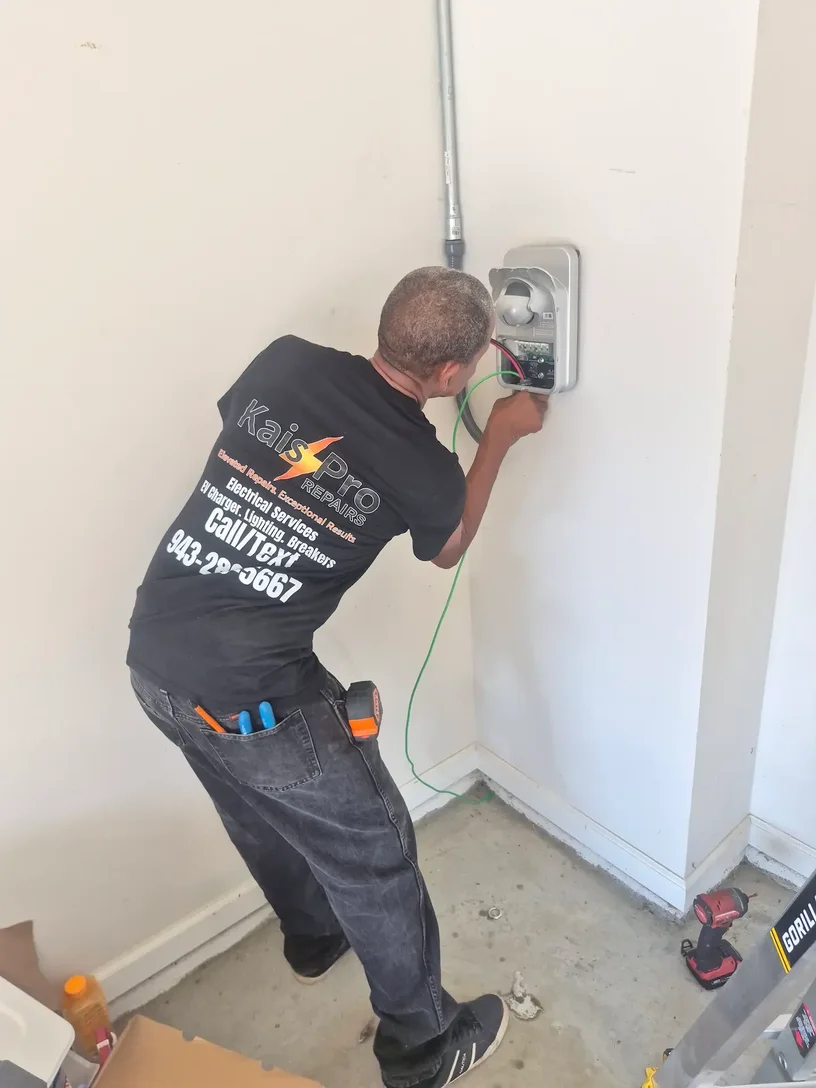 Technician terminating conductors inside the wall mounted ChargePoint charger during installation