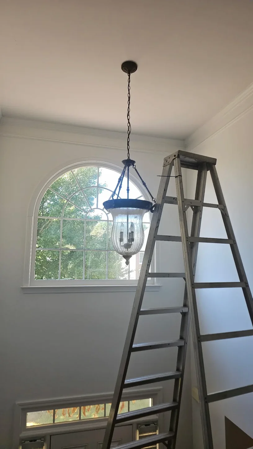 Original traditional chandelier before replacement in a two-story Alpharetta Georgia foyer