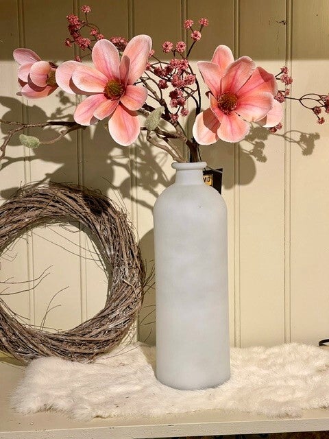 Fles in glas met gemengde takken.