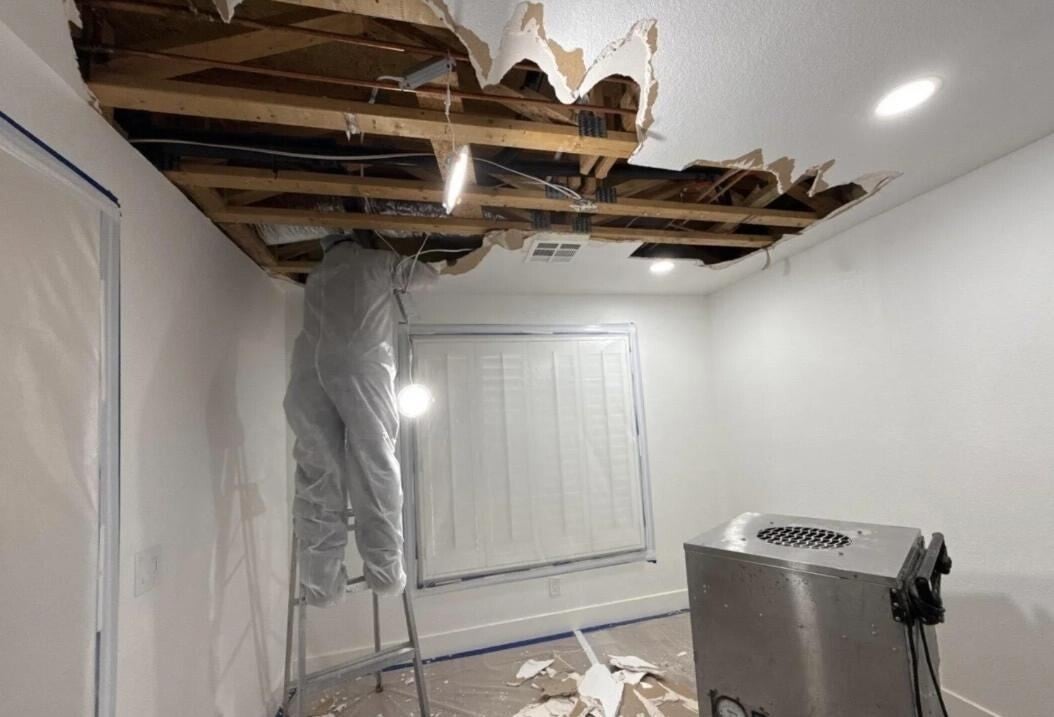 Technician inspecting an opened ceiling