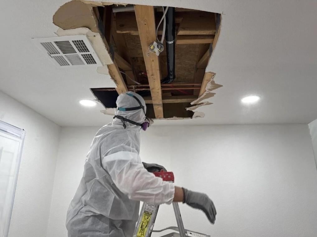 Technician removing a damaged ceiling