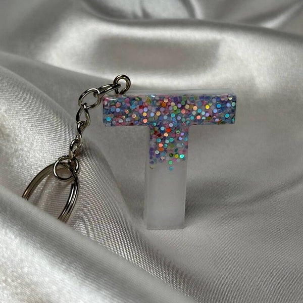 Resinschlüsselanhänger Buchstabe T mit weißem Glitzerhintergrund und buntem Glitzer im Vordergrund