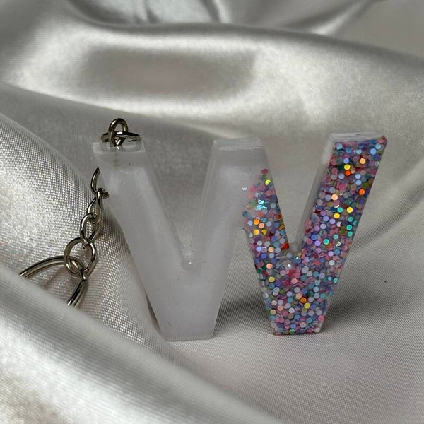 Resinschlüsselanhänger Buchstabe W mit weißem Glitzerhintergrund und buntem Glitzer im Vordergrund