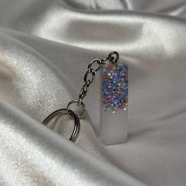 Resinschlüsselanhänger Buchstabe I mit weißem Glitzerhintergrund und buntem Glitzer im Vordergrund