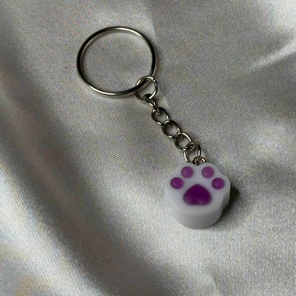 Resinschlüsselanhänger kleine Herzpfote in weiß-lila matt mit Glitzerschimmer