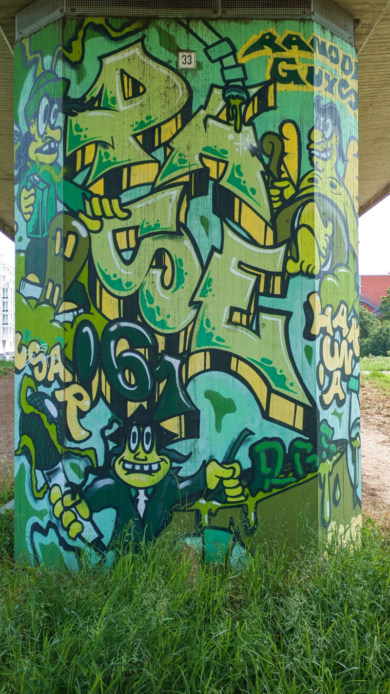 Viele grüne Graffiti-Schriftzüge auf einer Brückensäule – StreetArt Nippes