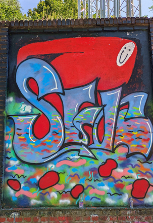 Bunter gesprayter Schriftzug auf einem Tor – StreetArt in Ehrenfeld