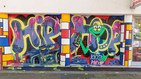 Bunter Schriftzug als Graffiti an einer Hauswand – StreetArt Köln