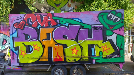 Farbig gesprayter Schriftzug auf einem Autoanhänger – StreetArt in Köln
