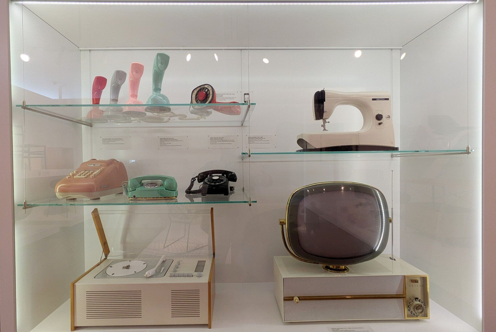 Auswahl an Telefonen in einer Glasvitrine im Mid Century Design im MAKK Museum
