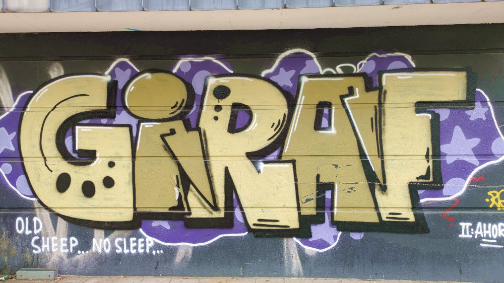Goldener GIRAF-Graffiti-Schriftzug auf Mauer – StreetArt Kalk