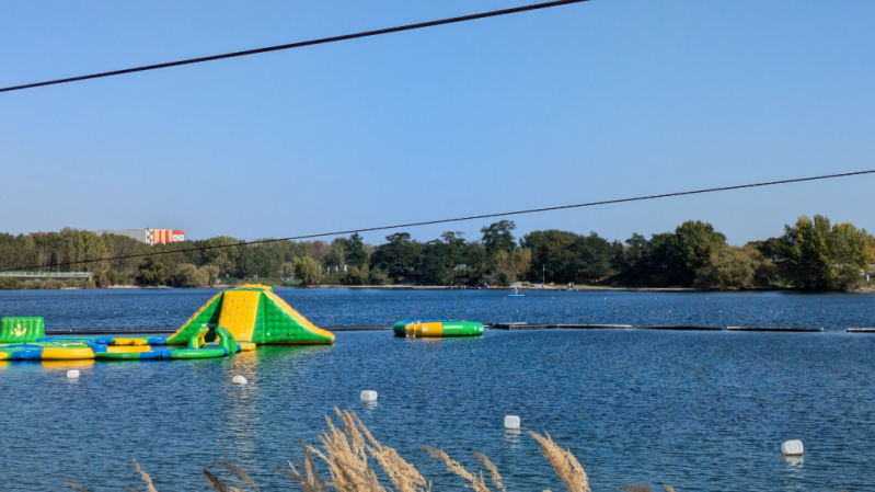 Blick auf bunte Hüpfburgen im Wasser des Fühlinger Sees, die Kinder zum Springen und Spielen einladen