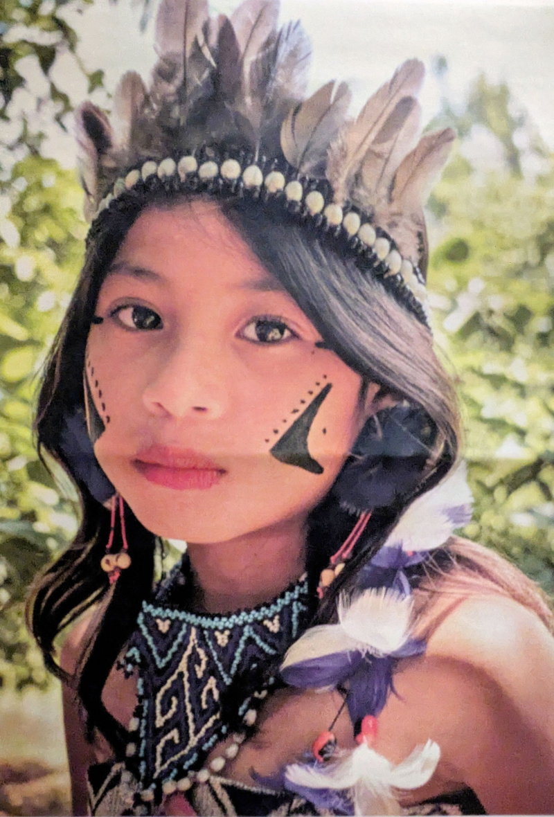 Junge Frau mit Federschmuck und festlicher Kleidung