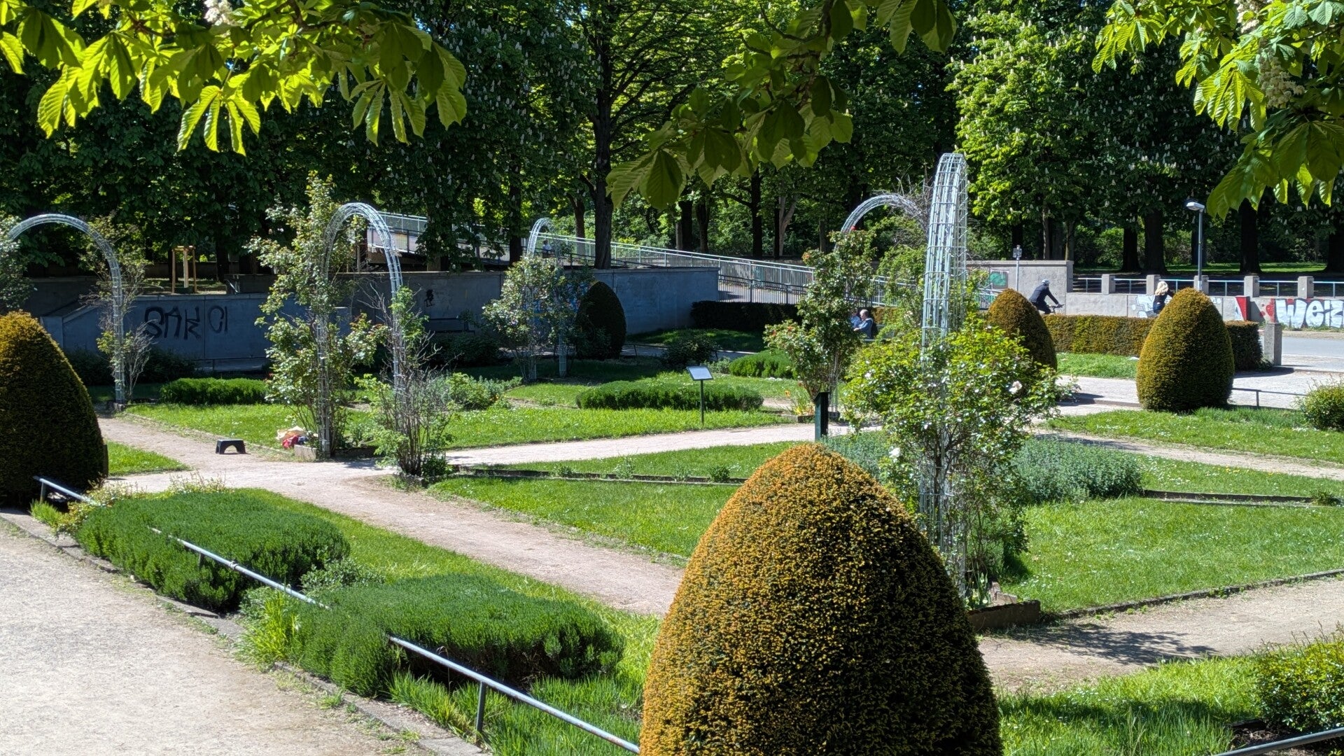 Sicht auf den wunderbar angelegten Garten im BlücherPark mit vielen Rosenbögen