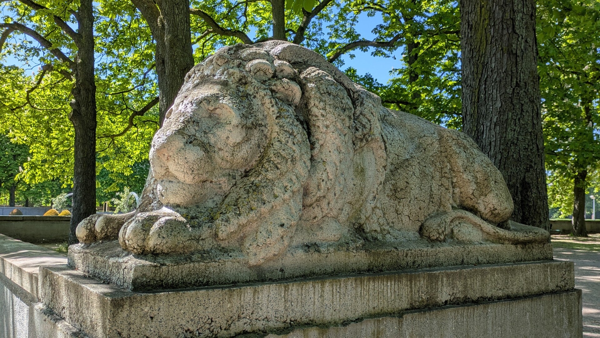 Eine steinerne Löwenskulptur bewacht den Eingang zum wunderschön gestalteten Garten