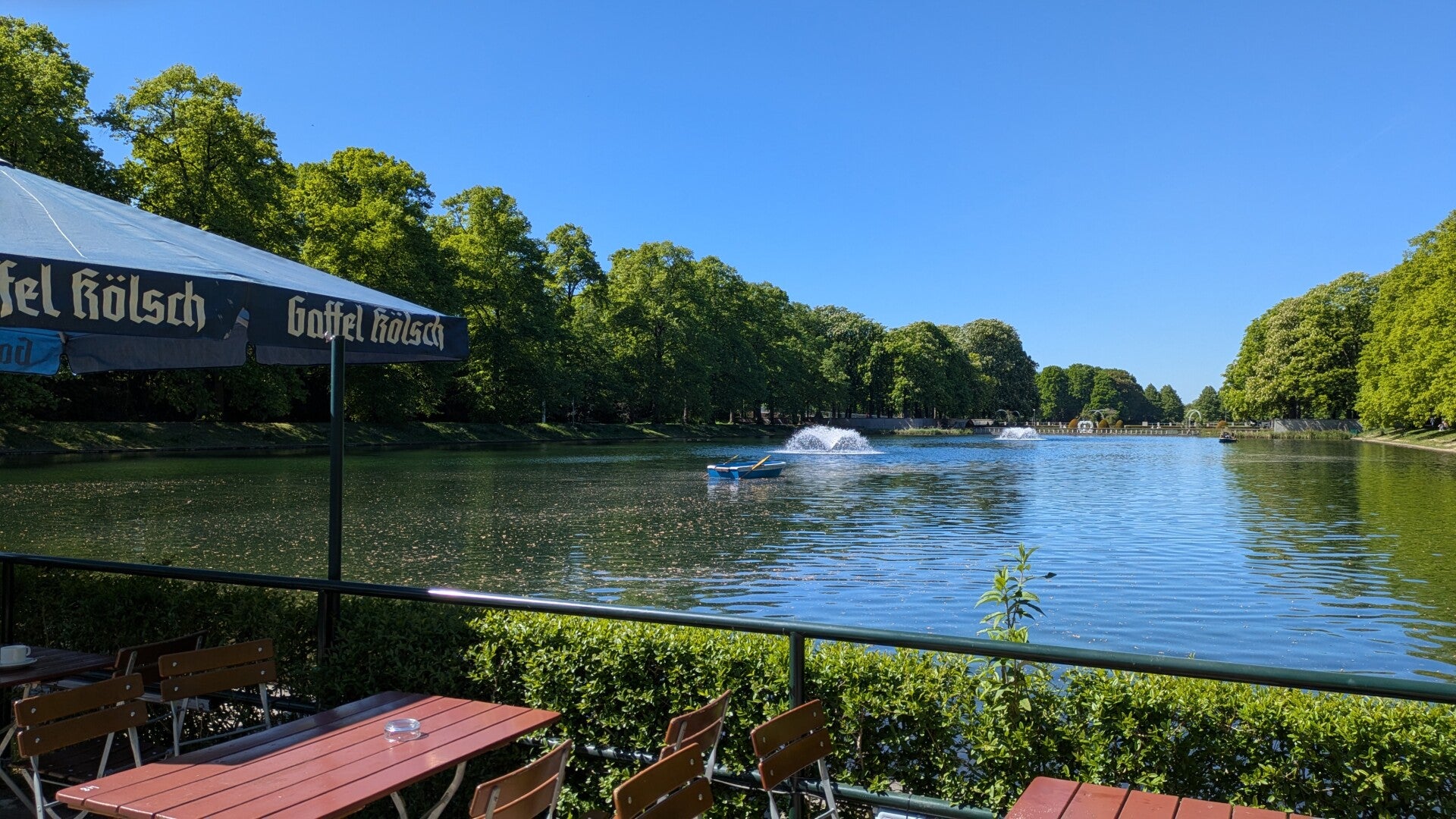 Blick von der Wirtschaft aus über den Weiher mit vielen Bierbänken und Sitzgelegenheiten im Blücher Park