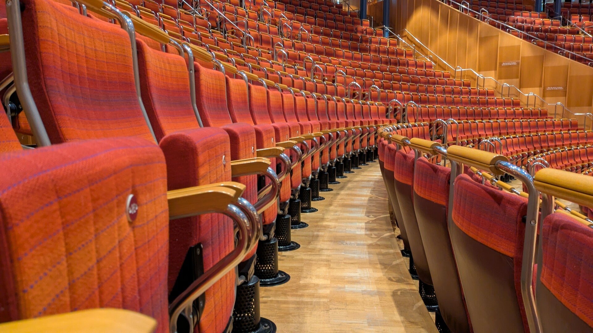 Blick auf ein Stuhlreihe in rötlichen Farben im Saal der Kölner Philharmonie
