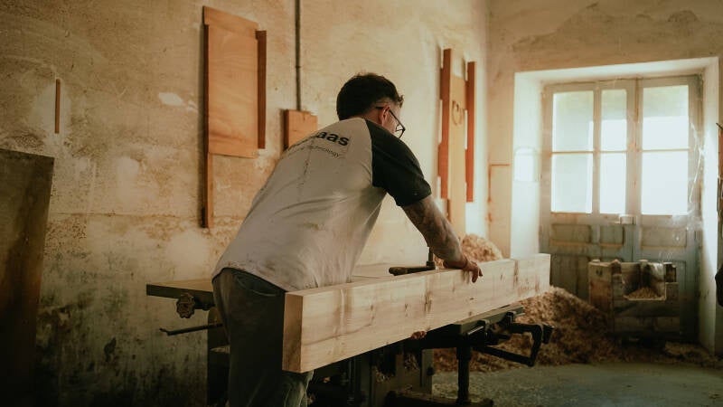 Séance photo artisan dans atelier, travail manuel et ambiance cinématographiq