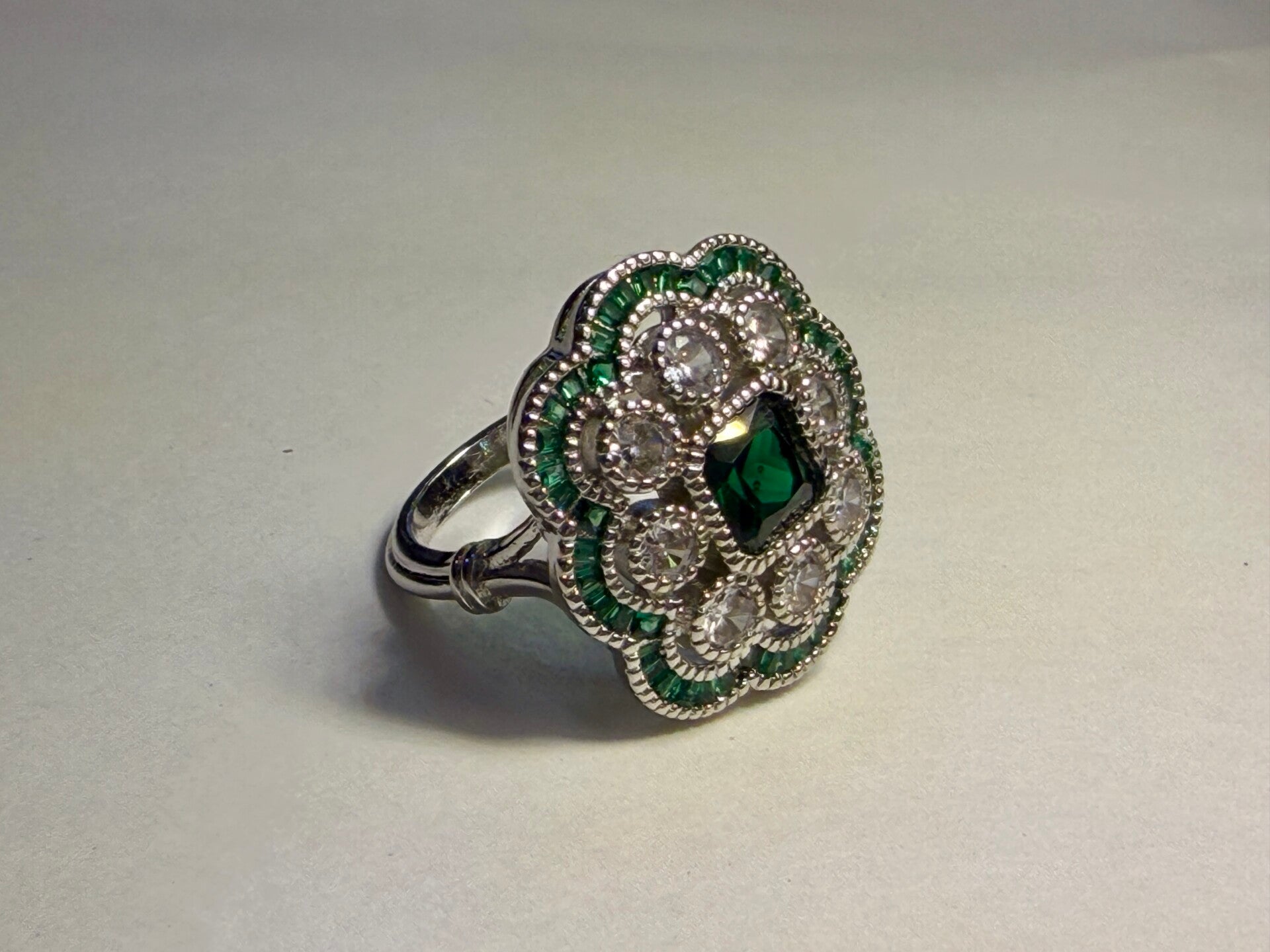 Bague argentée – Émeraude et détails floraux