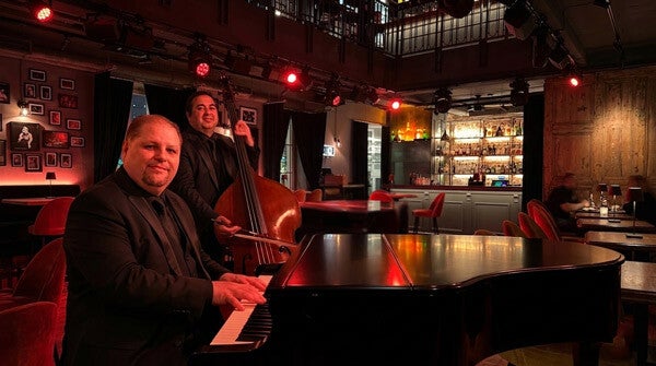 Live muziek duo met piano en contrabas speelt in een sfeervolle restobar