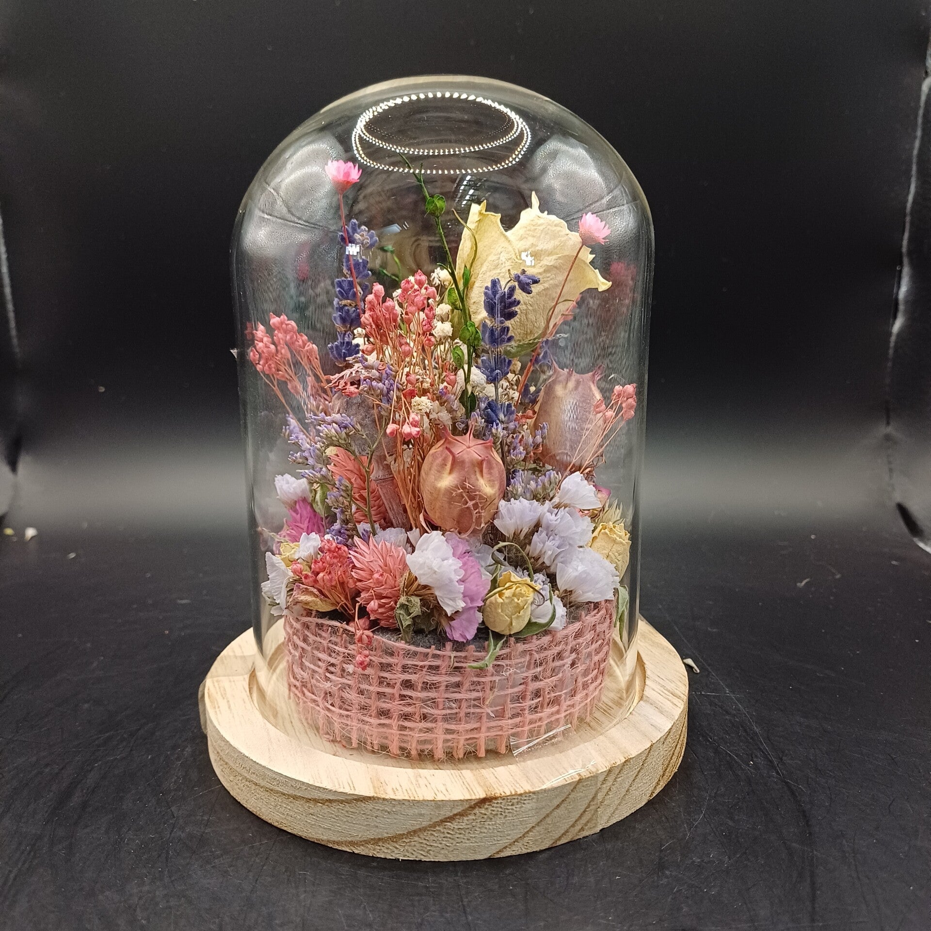 Stolpje met fleurige droogbloemen en een roos als middelpunt