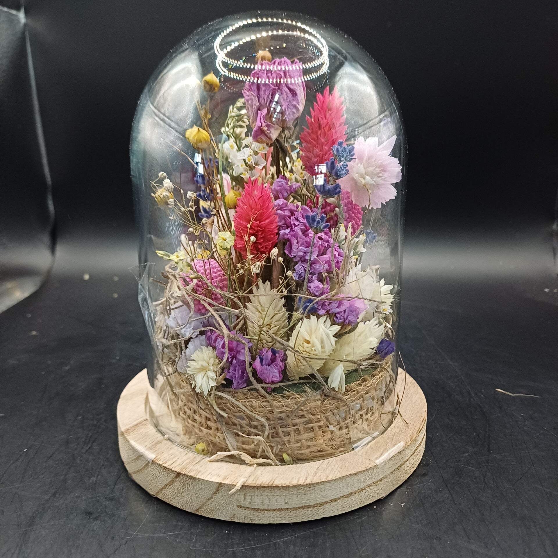 Stolpje met fleurige droogbloemen en een roos als middelpunt