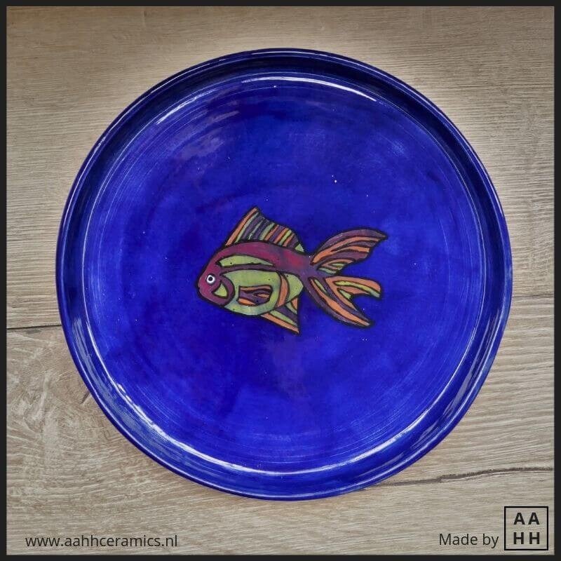 blauw bord met opstaande rand met afbeelding van een vis