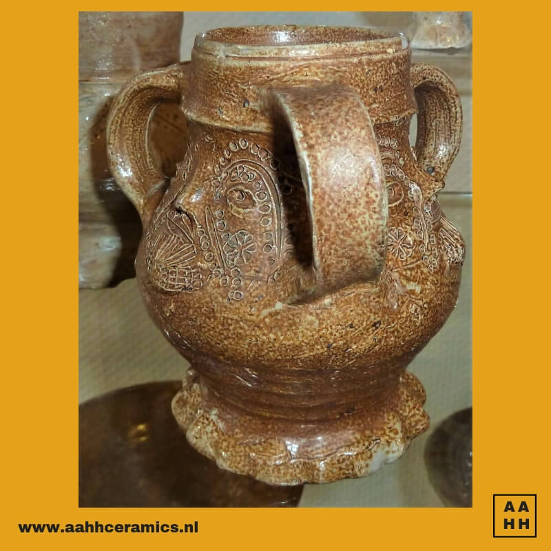 kruikje met gezicht op ronde buik, sta-rand met vingerafdruk en drie oren