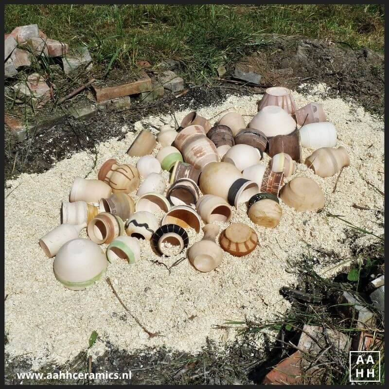 Alle werkstukken liggen naast elkaar op een dikke laag zaagsel