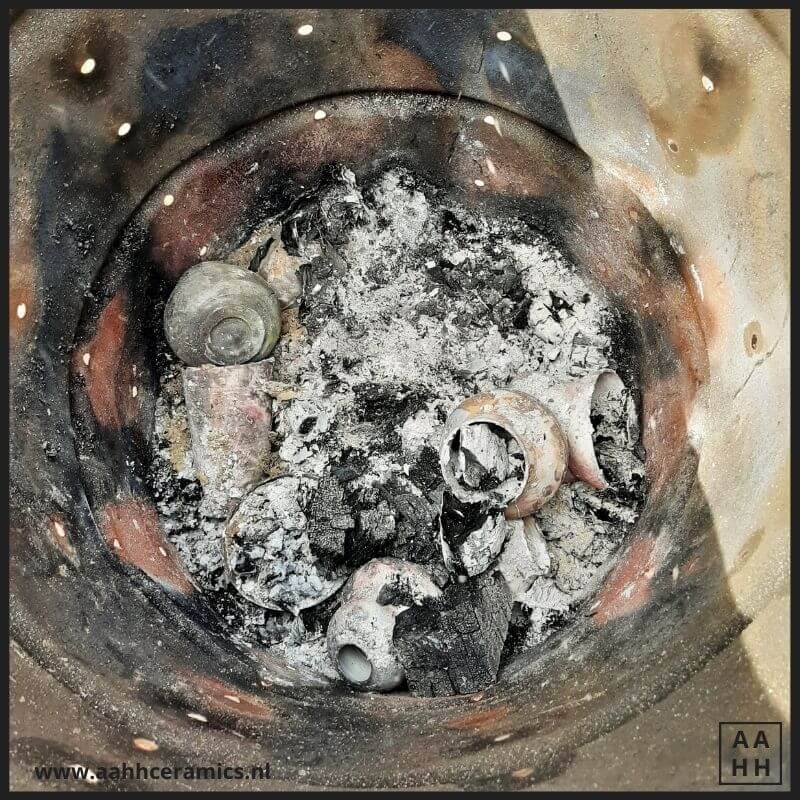 As en keramiek werkstukken in de ton na de stook - er is nog maar weinig hoogte over