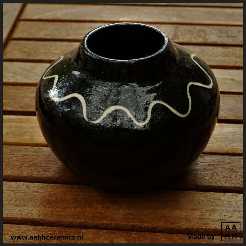 Buikvaasje met hals van zwarte klei met ingelegd wit golvend lijntje - geglazuurd