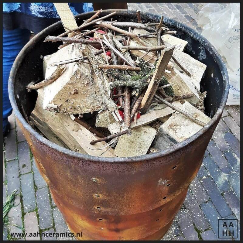 De grote ton is tot aan de rand gevuld met zaagsel, hout en daar tussen in onze werkstukken