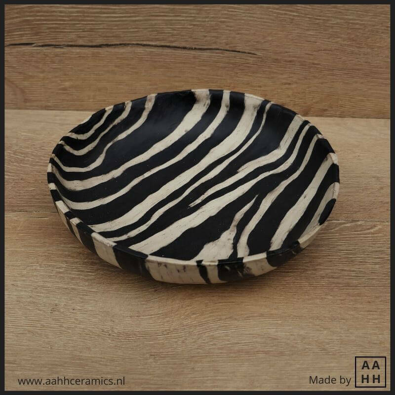 grote ronde schaal van rolletjes van zwarte en witte klei