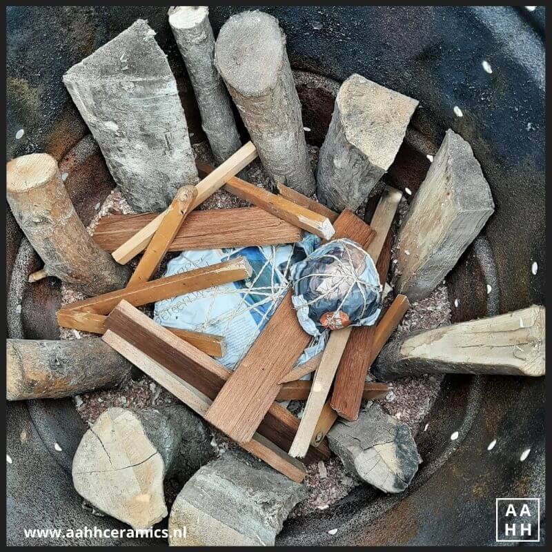 Mijn schaal onder in de ton op zaagsel met hout eromheen en er boven op.