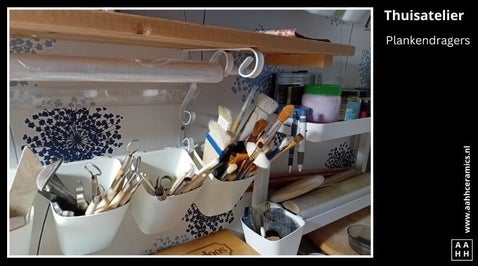 Keramiek atelier thuis - detail van plankendragers met krullen waarin gordijnroedes zijn opgehangen met hangbakjes etc