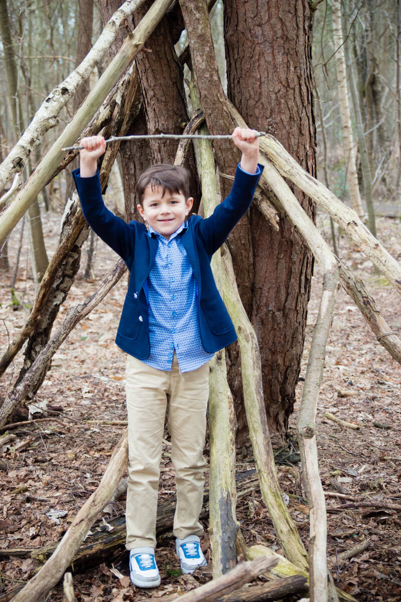 stoere jongen communie fotoshoot in bos in Geel