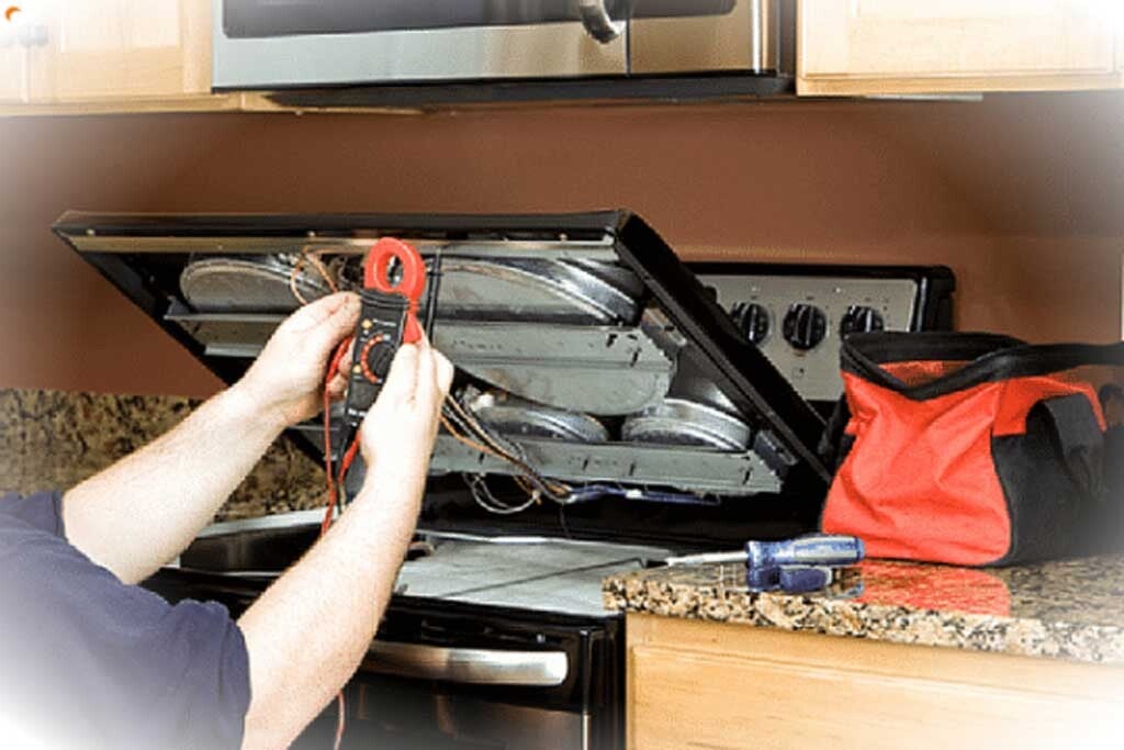 Appliance technician testing stove burner during repair 