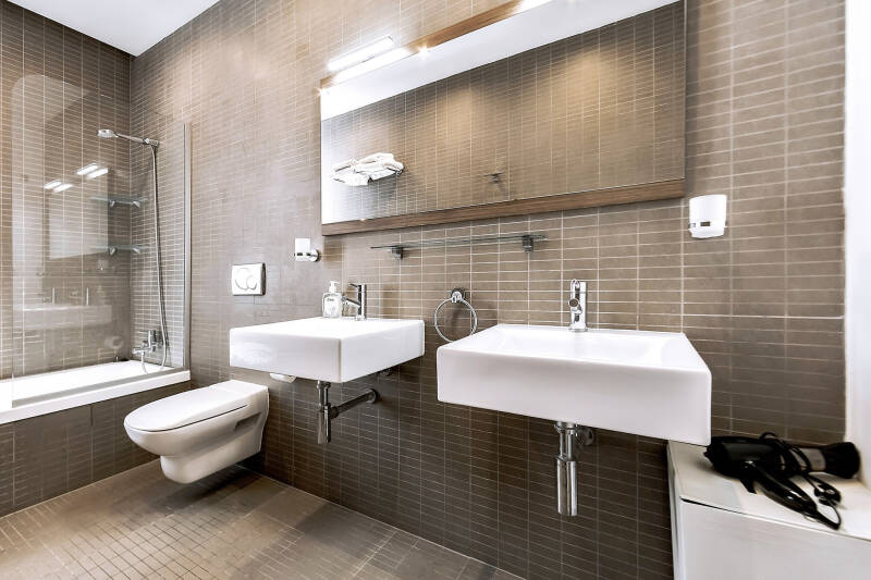Badkamer met twee wastafels en ligbad