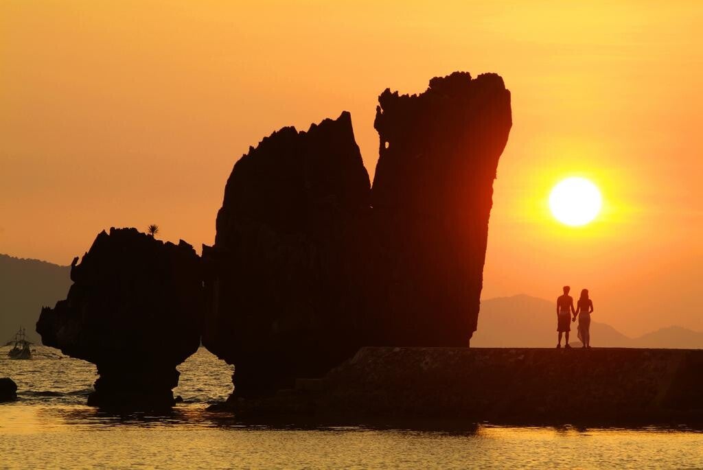 Stel bij zonsondergang tussen de rotsen van El Nido