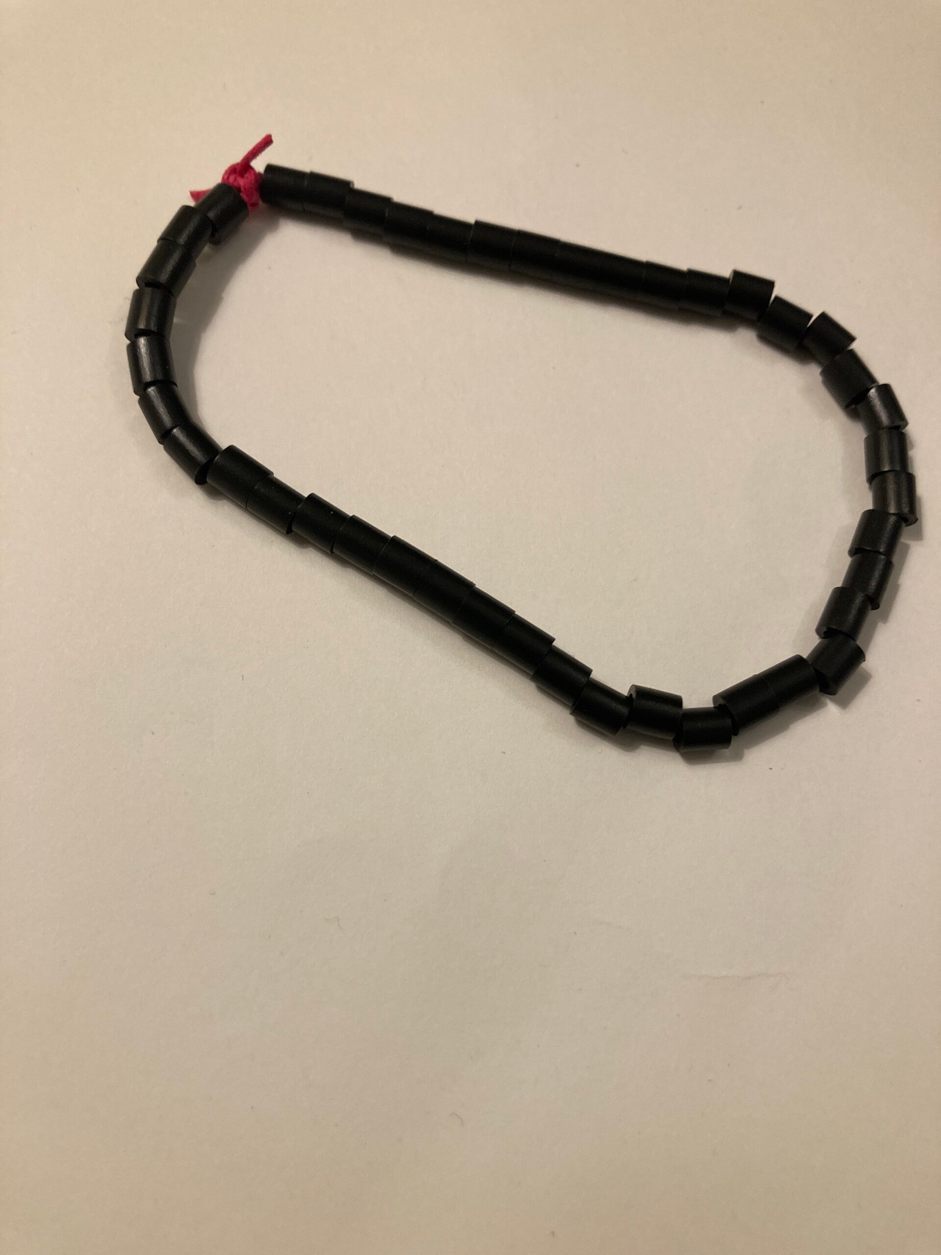 BRACELET Black Spacer Beads On Pink Cord Plastic Beads