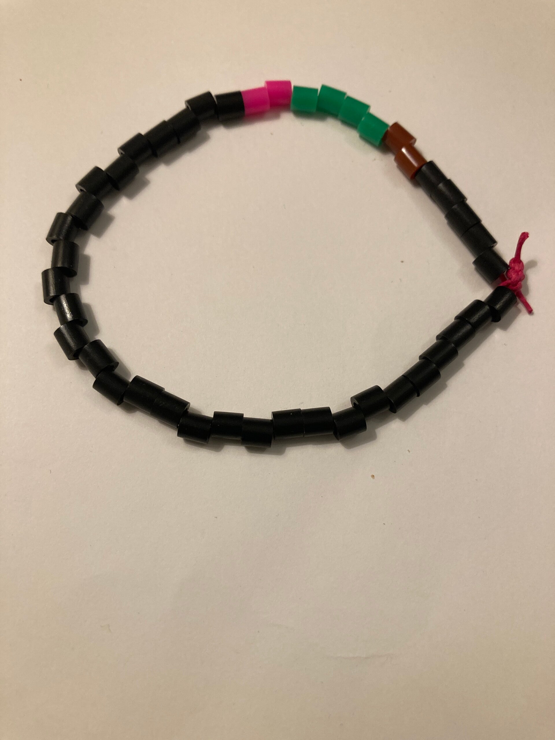 BRACELET Black Brown Green Pink Depicting A Flower Spacer Beads on Pink Cord