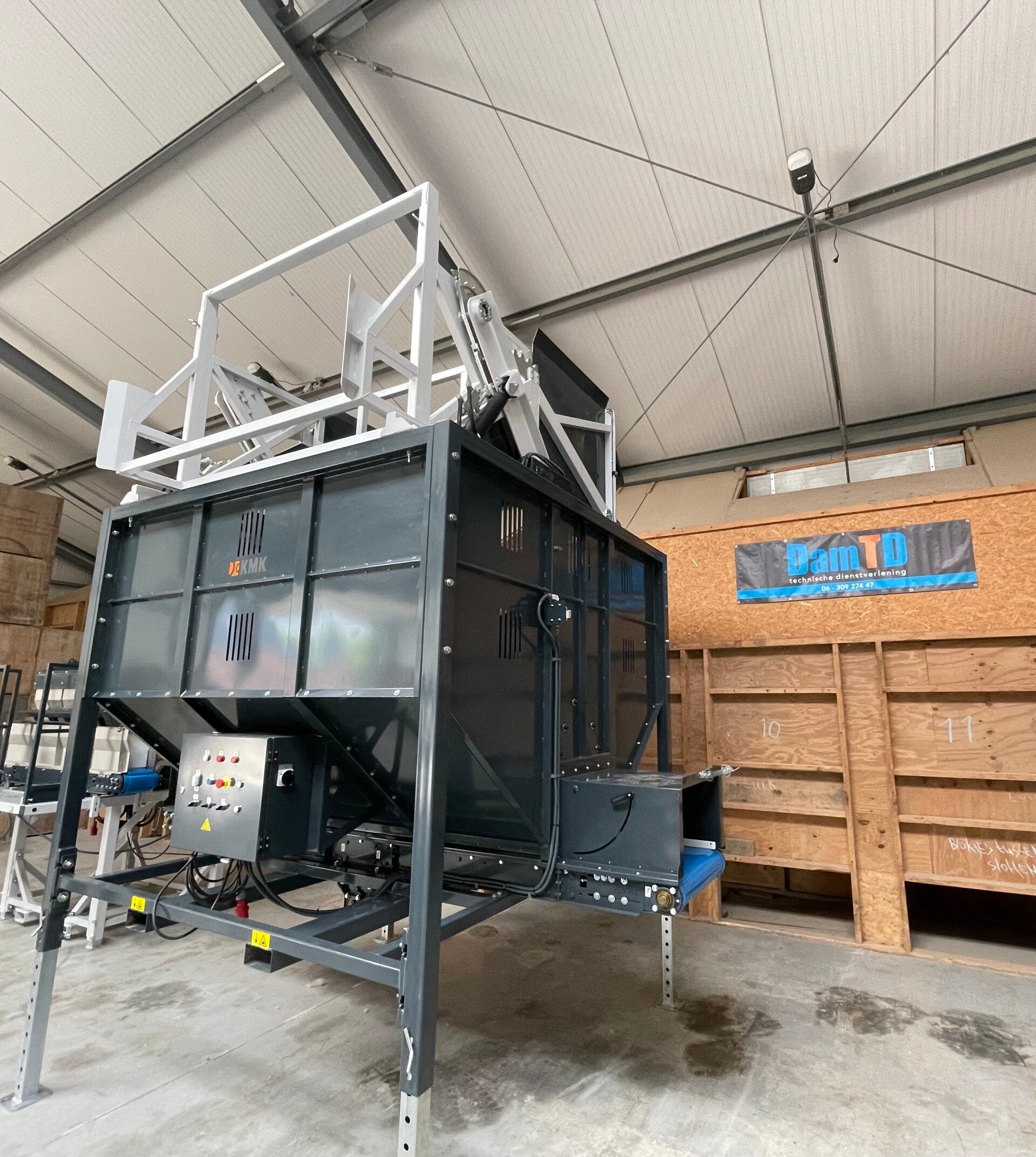 Zijaanzicht van de KMK BP stortbunker opgesteld voor productinvoer bij een sorteerlijn