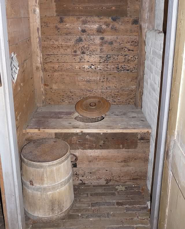 Het ouderwetse buiten toilet inclusief velletjes van krantenpapier om de billen te vegen.