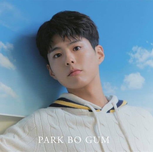 Park Bo-gum con sweter blanco y rallas amarillas y azules