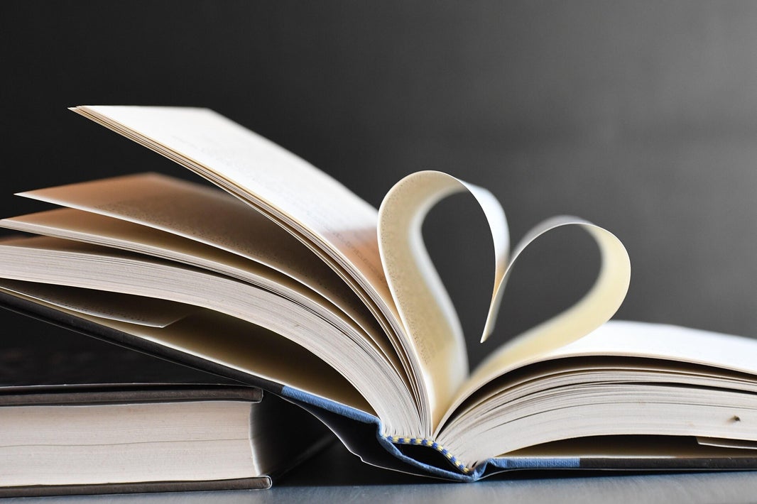 Libro abierto con dos hojas formando un corazón