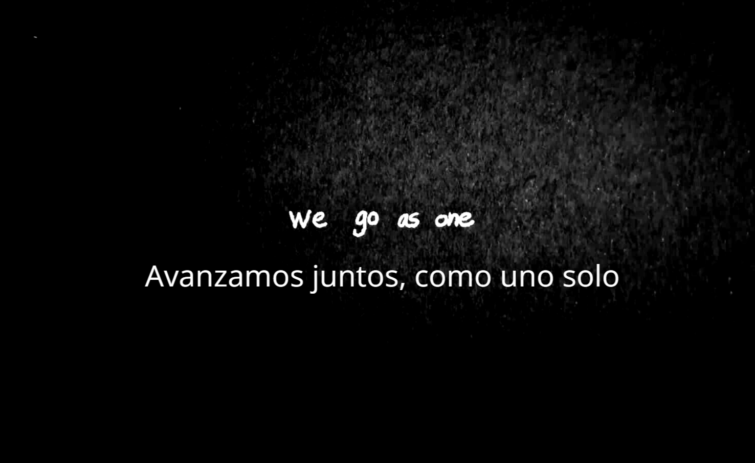 En un fondo negro está la frase en inglés "We go as are". Abajo su traducción interpretativa al español "Avanzamos juntos, com uno solo"