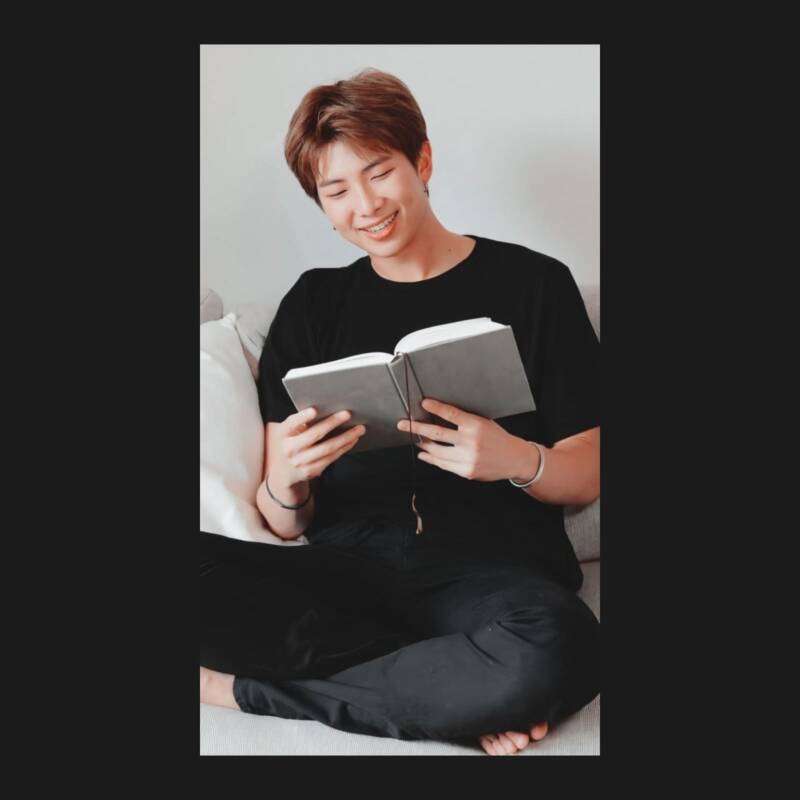 RM de BTS leyendo un libro comodamente