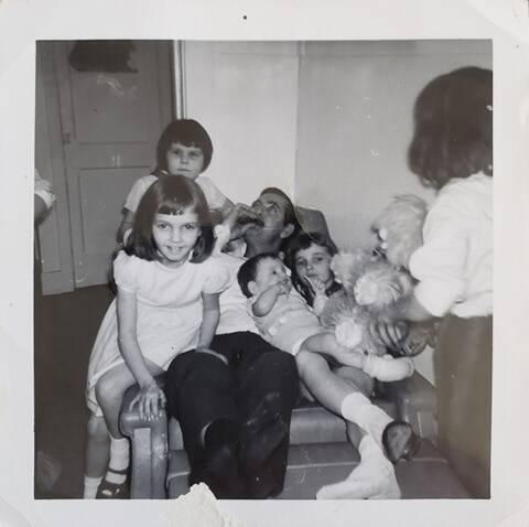 Monsieur Maltais jouant de l&#039;harmonica au milieu de ses enfants. Johanne est ensevelie au fond du fauteuil !