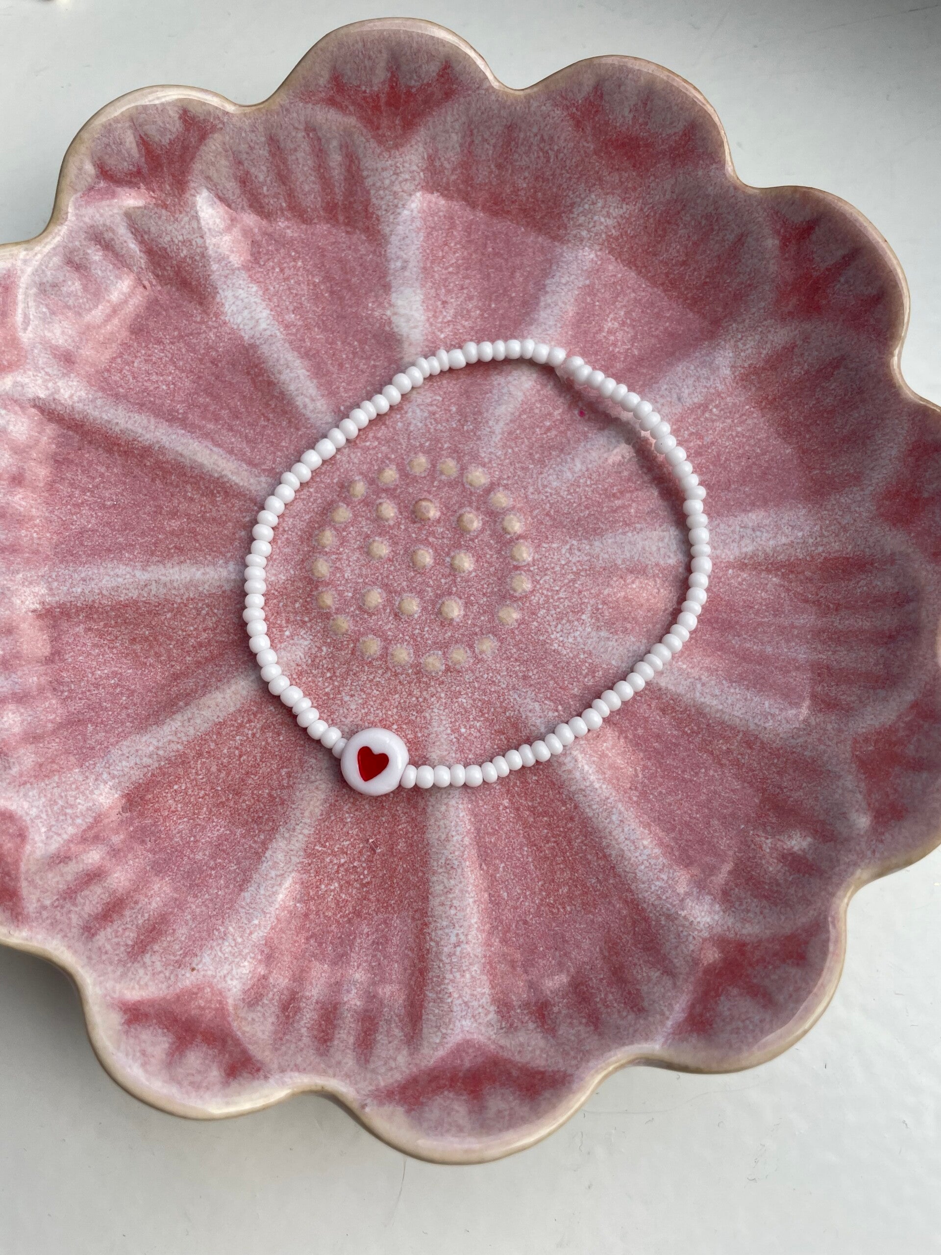 Wit armbandje met rood hartje